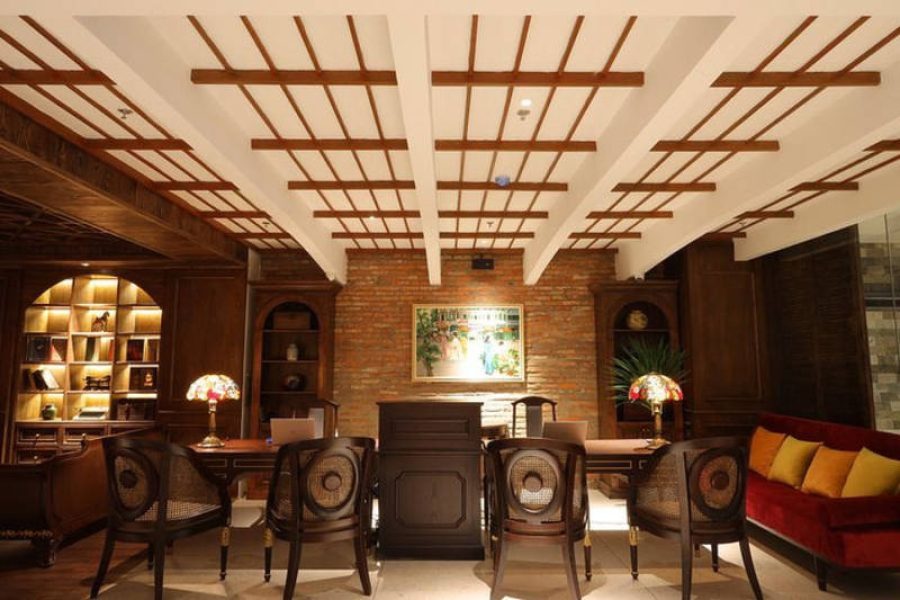 Elegant lounge with wooden ceiling, brick walls, and lit bookshelves