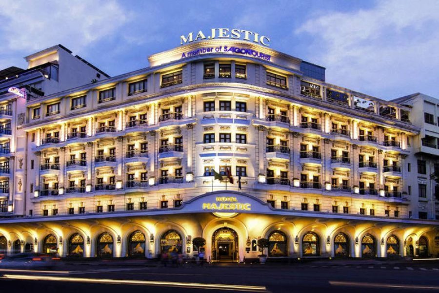 White colonial building lit up at twilight with arched entrance, balconies, and Majestic signage