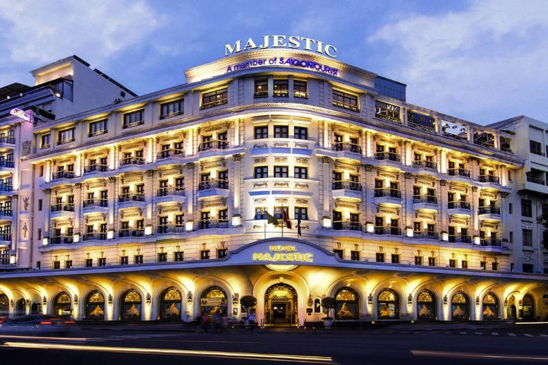 White colonial building lit up at twilight with arched entrance, balconies, and Majestic signage