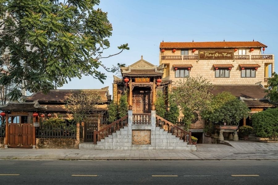 Exterior of a traditional Vietnamese wooden house restaurant with tiled roof