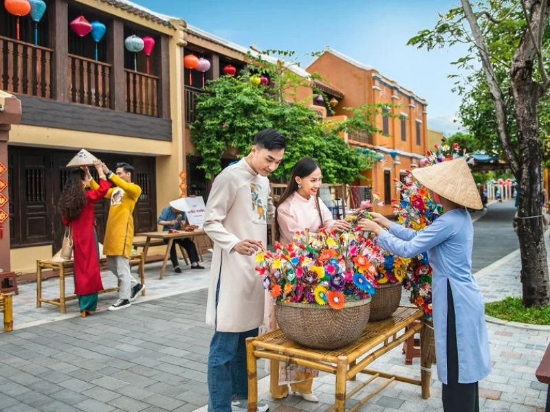 Tourists buying colorful lanterns in Hoi An street market