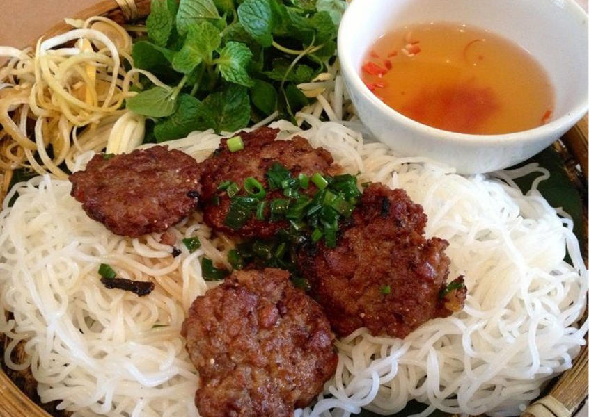 Vietnamese bun cha with grilled pork patties, noodles, and herbs