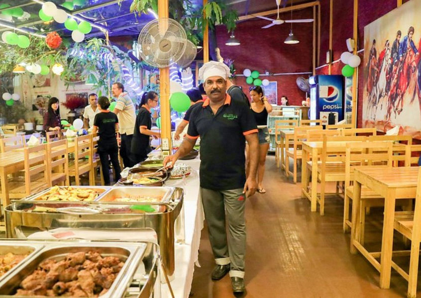 Chef standing next to a buffet line in a restaurant