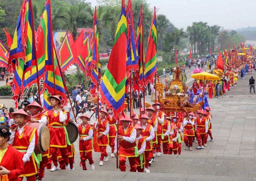 Grand ceremonial procession with traditional flags and costumes at the Hùng Kings' Temple Festival in Phú Thọ