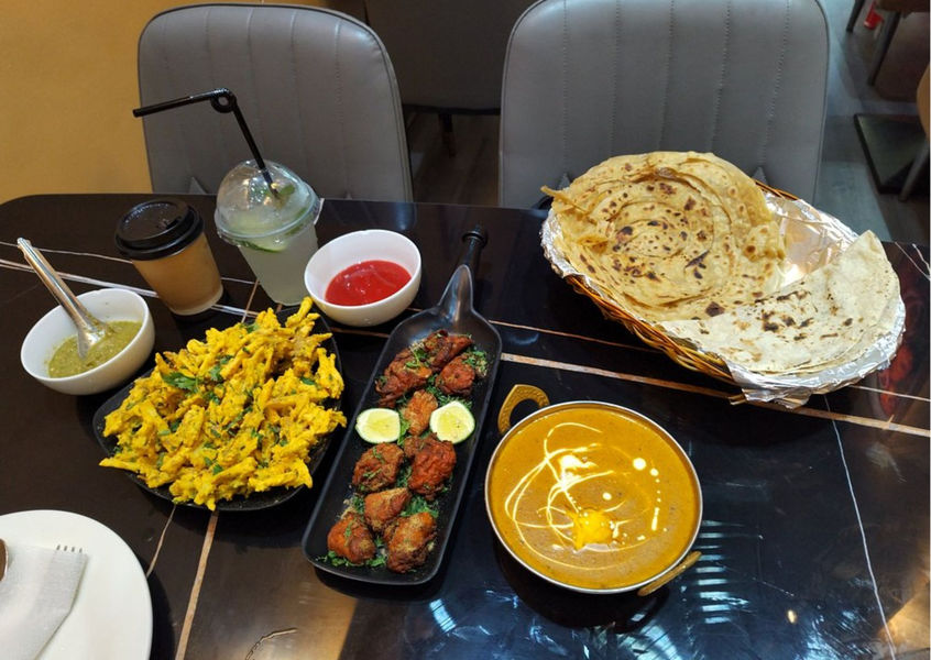 Indian food table setting with curry, naan, and pakora