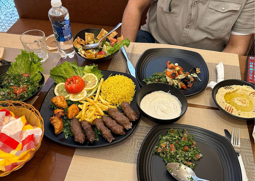 Middle Eastern meal with kebabs, yellow rice, and salad