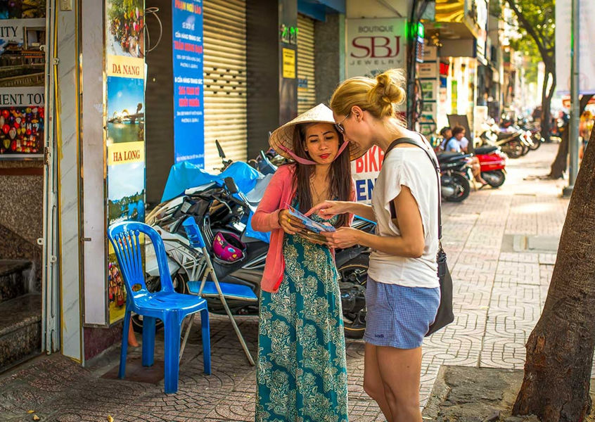 Solo female traveler getting directions from local woman in Da Nang