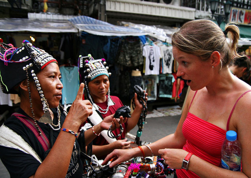 Tourist haggling with ethnic minority vendors at a Vietnamese market
