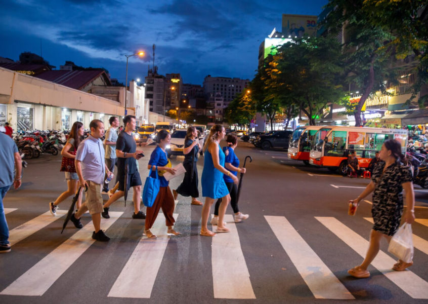 Tourists crossing a zebra crossing at night in Ho Chi Minh City