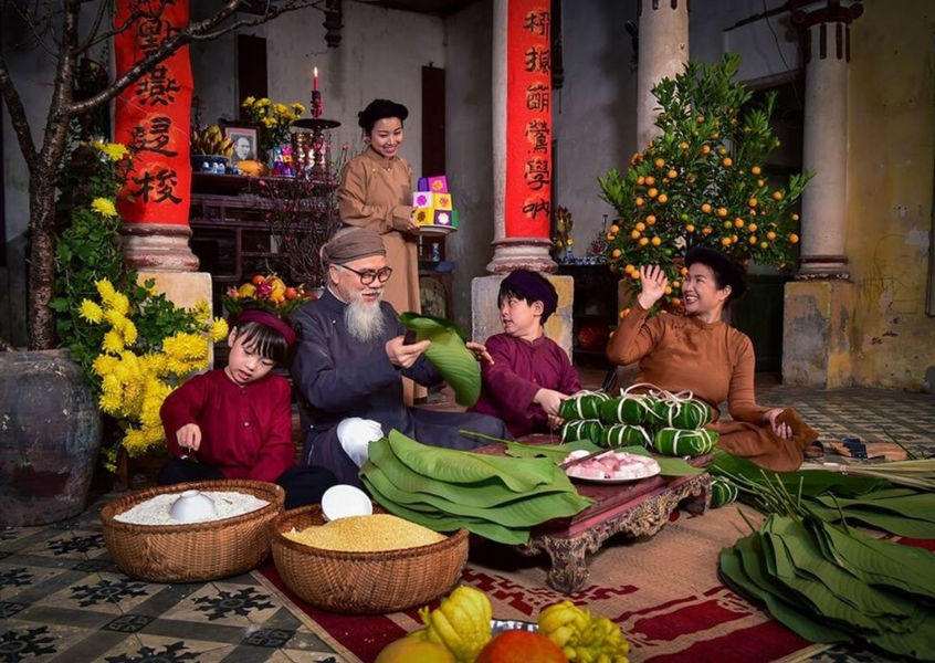 Vietnamese family making banh chung together for Tet New Year celebration