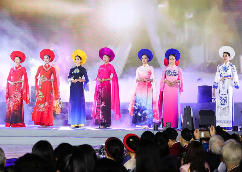 Vietnamese women in colorful áo dài traditional dresses performing on stage