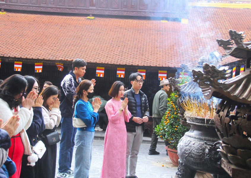 Visitors praying with incense at a Buddhist pagoda in Vietnam