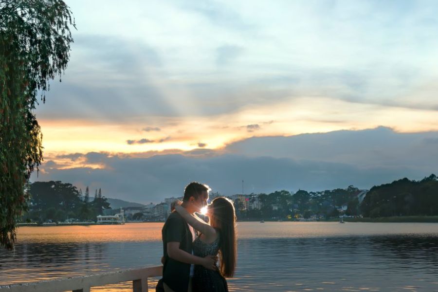 Couple embracing at sunset by Da Lat lake