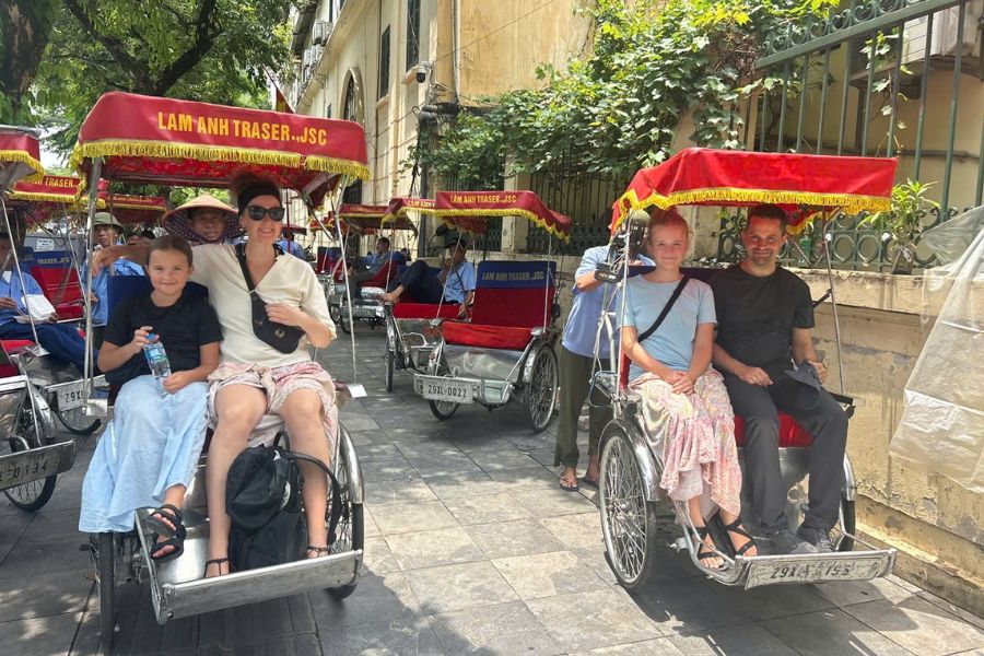 Family riding cyclos in Hanoi Old Quarter street
