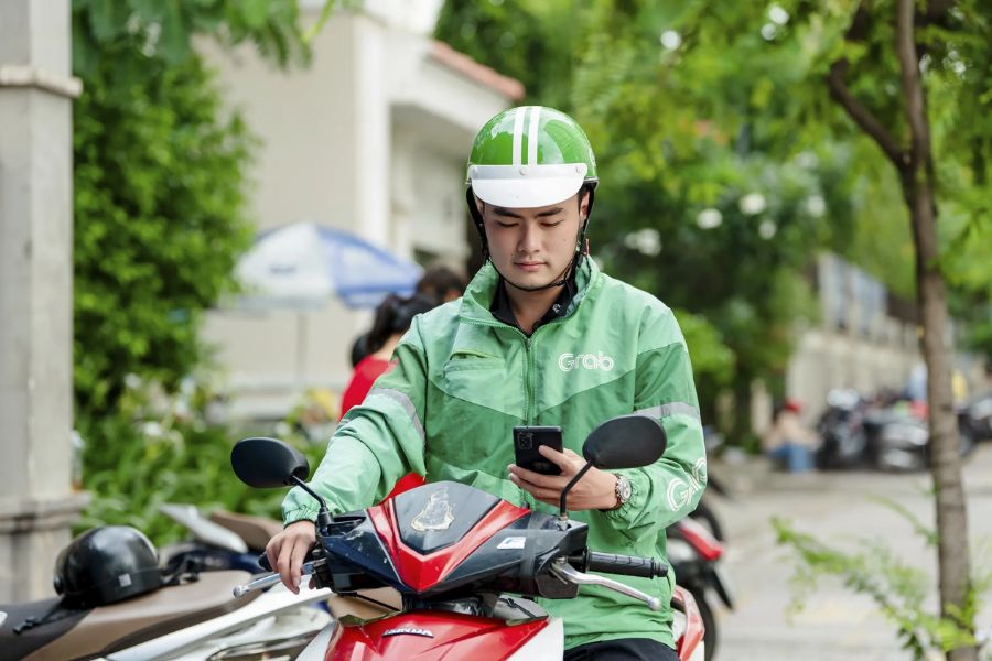 Grab motorbike driver checking phone before a ride