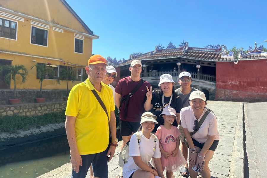 Multi-generation tour group posing at Hoi An's Japanese Covered Bridge