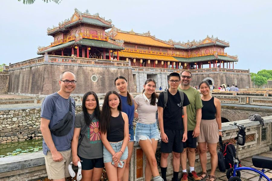 Multi-generation family visiting Hue's Imperial City gate