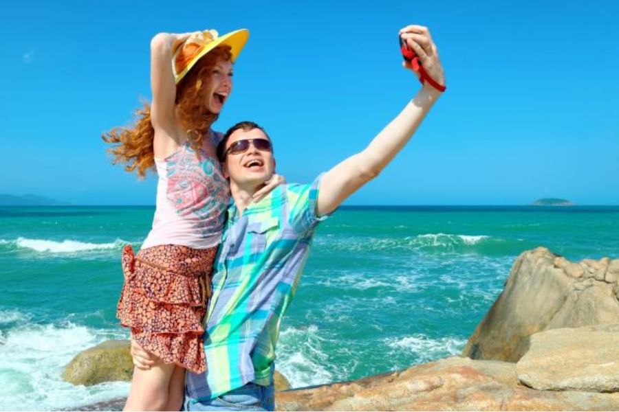 Couple taking selfie on rocks along Nha Trang coast