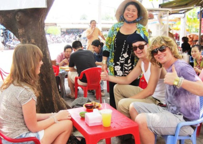 Polish tourists enjoying street food with Hoi An vendor
