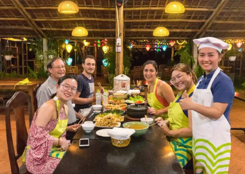 Travelers enjoying dinner after Vietnamese cooking class