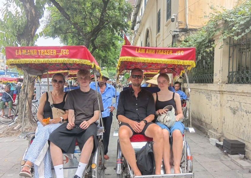 Family riding cyclos through Hanoi Old Quarter