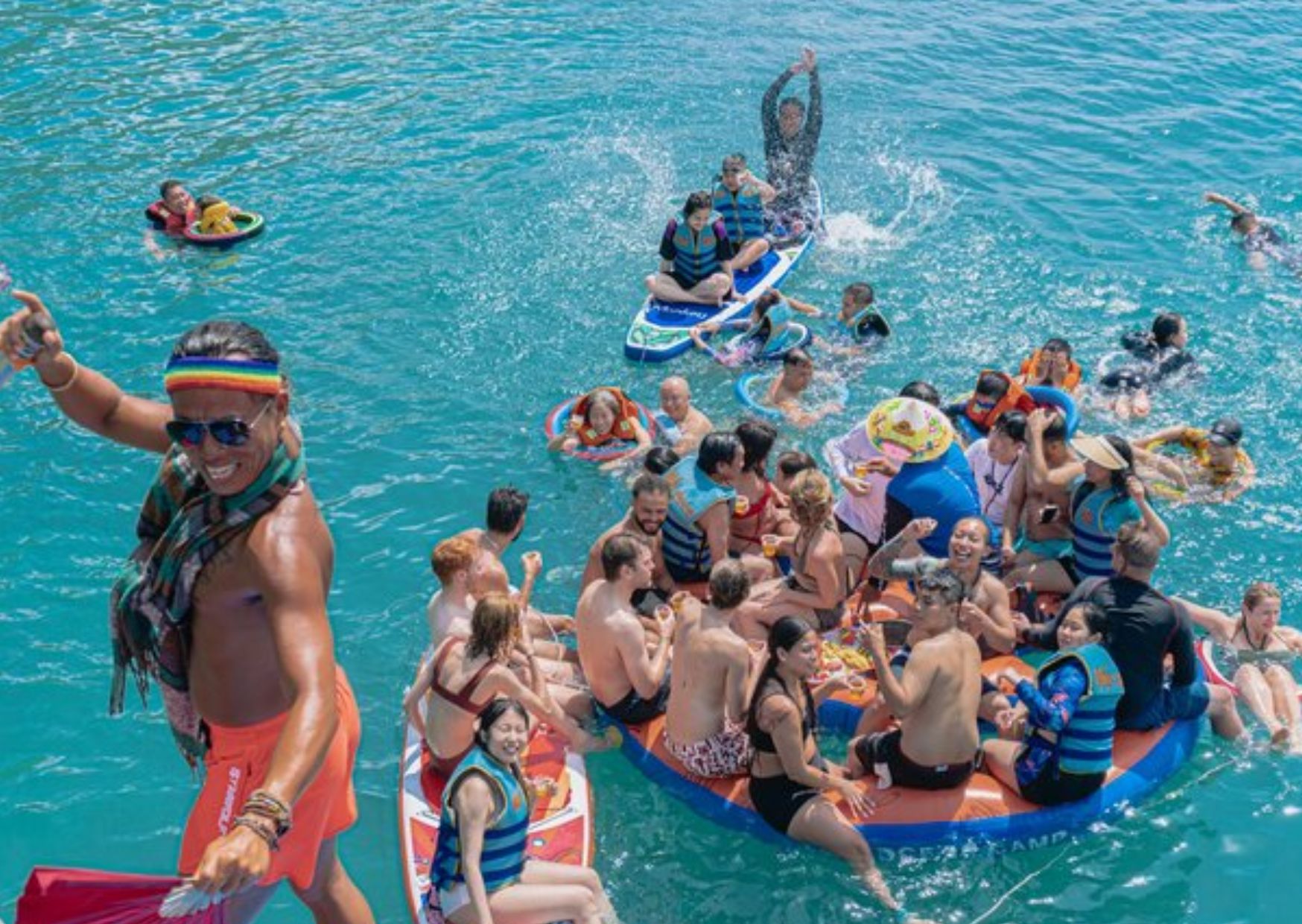 Group of tourists floating on inflatables during a boat trip