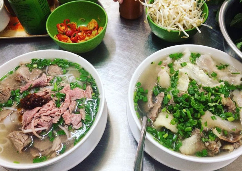 Two bowls of Vietnamese phở noodle soup with beef and herbs