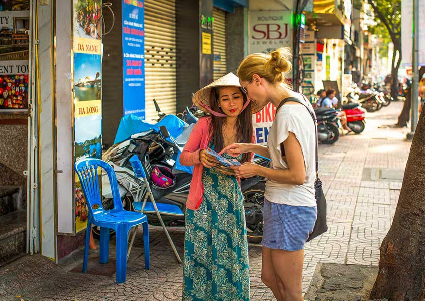 Tourist asking a local vendor for directions in Hanoi Old Quarter
