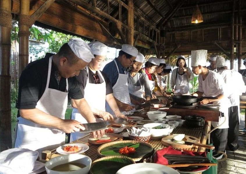 Group prepping ingredients at Vietnam cooking class table