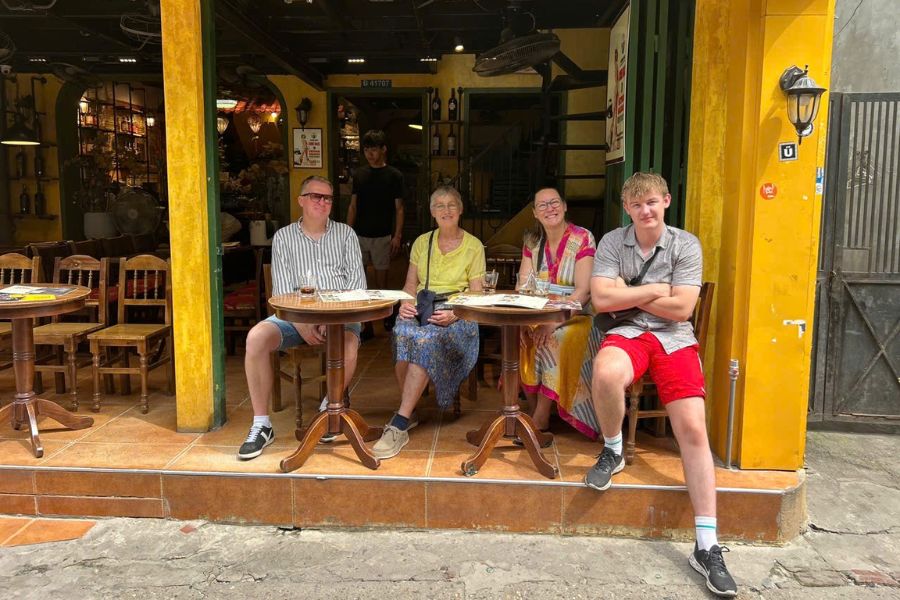 Group of travelers relaxing at an outdoor street cafe in Vietnam