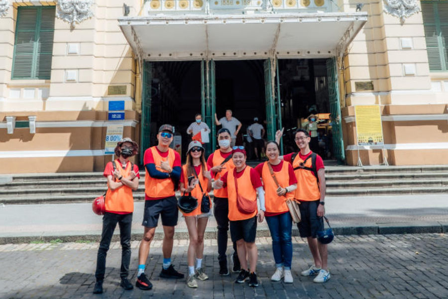 Team in orange vests outside a colonial building in Saigon