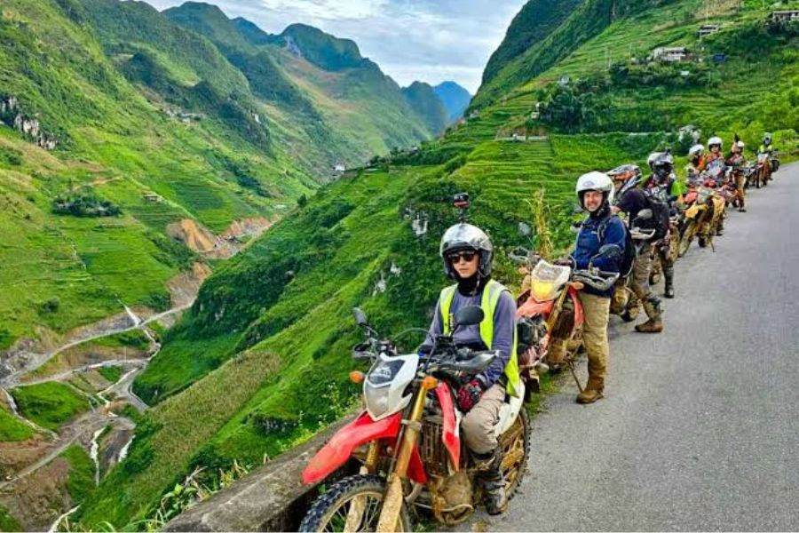 Dirt bike riders pause on Ha Giang mountain road, Vietnam