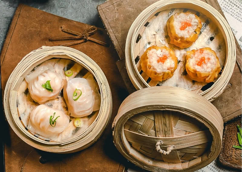 Steamed dim sum dumplings and siu mai in bamboo baskets