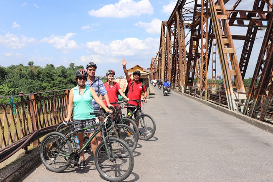 Cyclists pausing on Long Bien Bridge during a Hanoi cycling tour