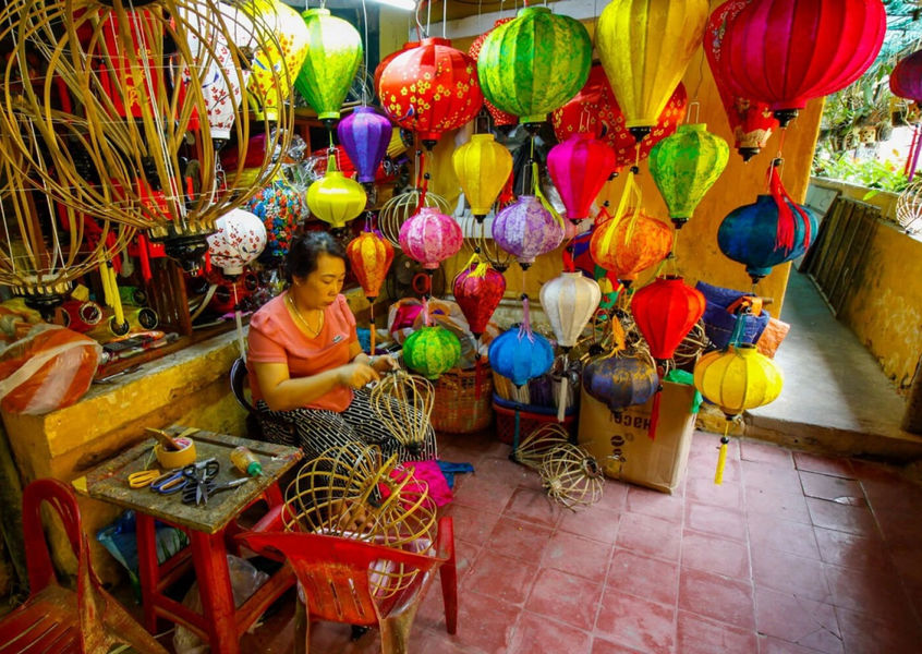 Local artisan handcrafting colorful silk lanterns at a workshop in Hoi An Ancient Town