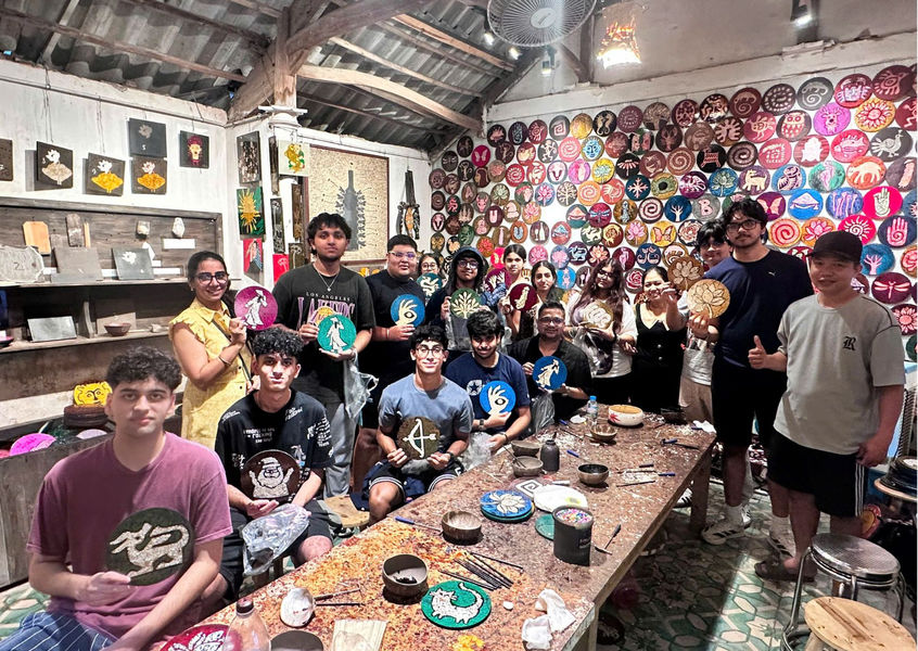 Indian group painting wicker tray crafts at workshop