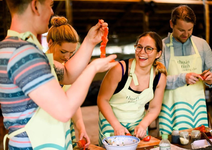 Small group laughing during a Vietnamese cooking class