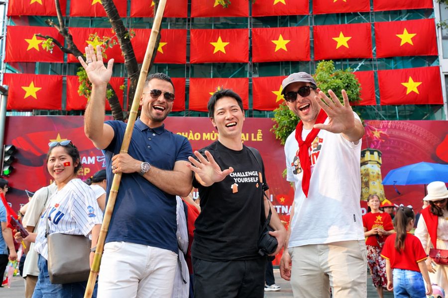 Travelers joining a local street festival with Vietnamese flags