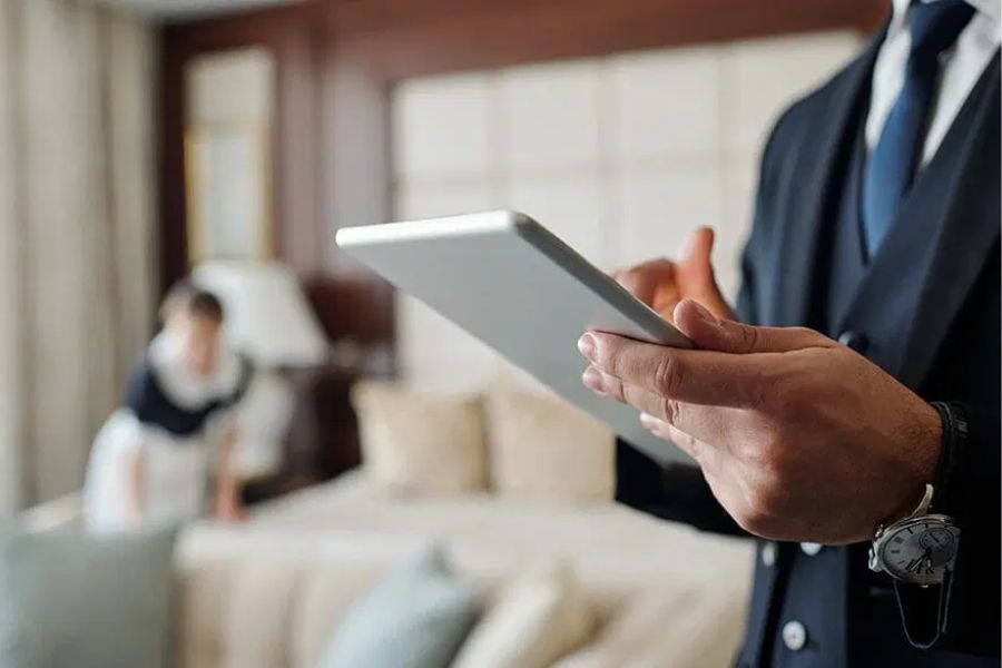 Hotel manager checking a room with a tablet during a site inspection