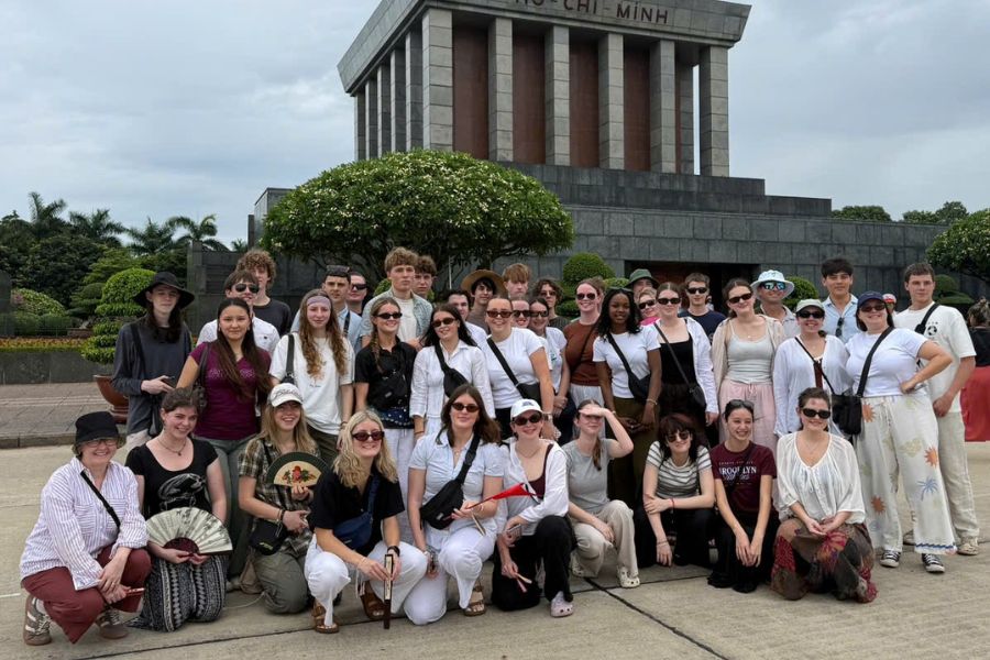 Large tour group posing outside the Ho Chi Minh Mausoleum in Hanoi