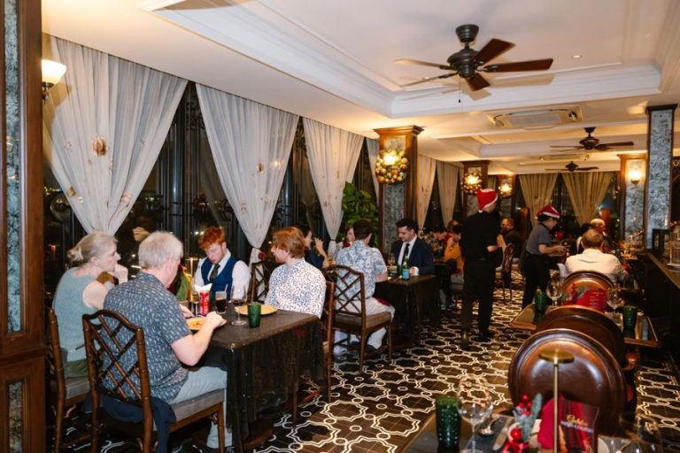 International travellers enjoying dinner in an elegant colonial-style restaurant in Vietnam