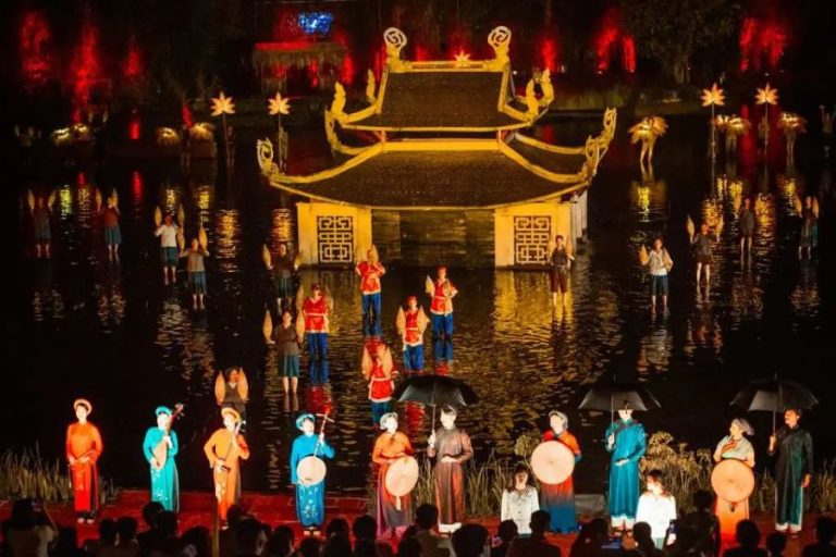Traditional Vietnamese cultural performance on an illuminated water stage at night